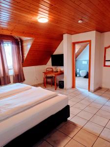a bedroom with a bed and a wooden ceiling at Hotel zur Schlemmerscheune in Weilerbach