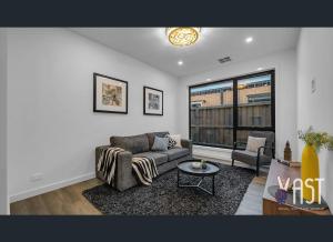 a living room with a couch and a table at Cozy Private Room Family Home Close to Airport in Donnybrook