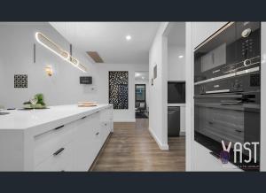 a kitchen with white counters and a stove top oven at Cozy Private Room Family Home Close to Airport in Donnybrook