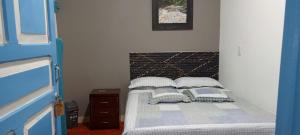 a bedroom with a bed with two pillows on it at hospedaje casa de niebla in Salento
