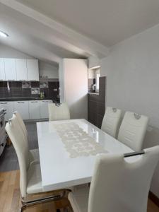 a kitchen with a white table and white chairs at Apartment NAV in Plav