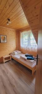 a bedroom with a bed in a wooden cabin at Solińskie Podgórze in Solina