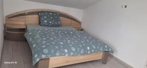 a small bedroom with a bed with a green comforter at Ferienwohnung am Waldrand 1 in Stary Przybsław