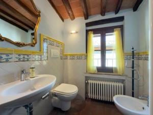 a bathroom with a sink and a toilet and a window at Le Torri View Apartment - San Gimignano in San Gimignano