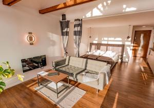 a living room with a bed and a couch at Pillanat Wellness Kabin in Bánk