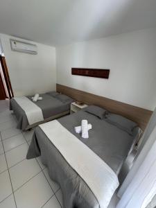 two beds in a hotel room with towels on them at Iloa Residence V13 Beach - localização privilegiada in Barra de São Miguel