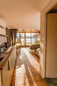 a kitchen and living room with a view of the ocean at Pillanat Wellness Kabin in Bánk