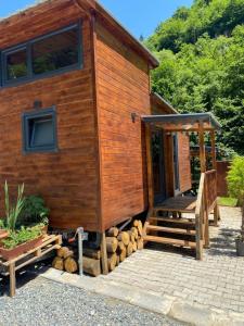 a wooden cabin with a staircase leading to the door at Lahza Tiny House in Çamlıhemşin