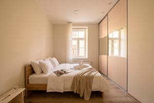 a bedroom with a bed with white sheets and a window at Bright 73m2 Apartment - Blaumana Street Central in Riga