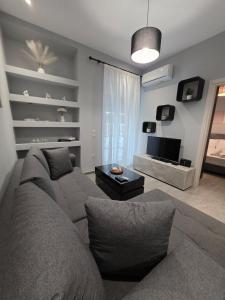 a living room with a couch and a television at SeDi Cozy Apartment in Chios