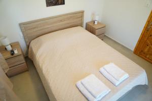 a bedroom with a bed with two towels on it at Villa Noema Kineta in Kineta +57 photos