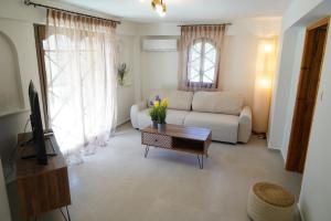 a living room with a couch and a coffee table at Villa Noema Kineta in Kineta
