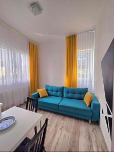 a living room with a blue couch and a table at Villa Azalia in Jastrzębia Góra