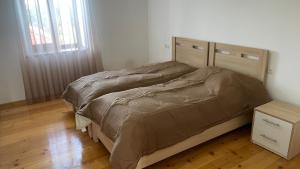 a bedroom with a bed with a wooden head board at Nia's Guesthouse in Zemo Alvani +11 photos