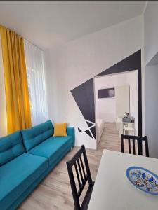 a living room with a blue couch and a table at Villa Azalia in Jastrzębia Góra