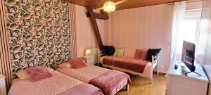 a small room with two beds and a tv at Le Clos des chênes rouges in Corrobert