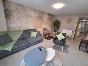 a living room with a couch and a table and chairs at Un Air de Poudlard in Bogny Sur Meuse