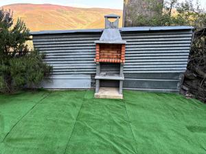 a small house with a green lawn with a stool at Casa Villafeile in Villafeile