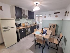 a kitchen with a table and chairs and a refrigerator at Un Air de Poudlard in Bogny Sur Meuse
