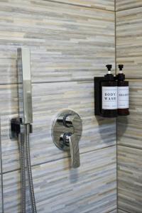 a shower head and a soap dispenser on a wall at Casa Sangiorgio Srl in Treviglio