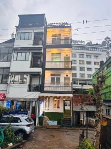 a tall building with a car parked in front of it at MSP Amma Cottage in Munnar