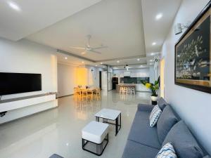 a living room with a blue couch and a flat screen tv at Mermaid-Oasky-50m to ThápTamThắng&Biển in Vung Tau