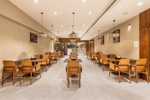 a restaurant with tables and chairs in a room at SkkyLight Lords Inn Nanded in Nānded