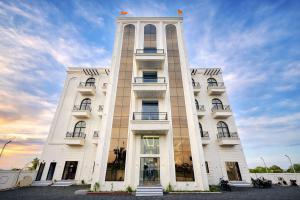 a tall white building with a sky in the background at Mandhata Riverview Palace in Mortakka