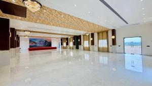 a large hall with a white floor and a chandelier at Mandhata Riverview Palace in Mortakka