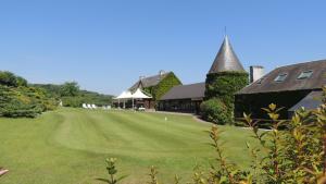 a golf course with a green and a building at Hotel du Golf de Clécy in Clécy