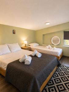 zwei Betten in einem Hotelzimmer mit Handtüchern darauf in der Unterkunft Enervillas 2030 in Káto Achaḯa
