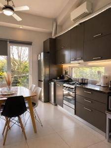 eine Küche mit Edelstahlgeräten und ein Tisch mit Stühlen in der Unterkunft Enervillas 2030 in Káto Achaḯa