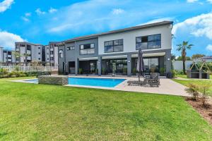 a house with a pool and a lawn at Chanty Serenity- workstation, gym, backup power &Pool in Sandton +24 photos