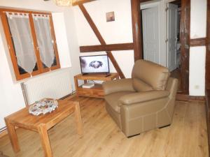 a living room with a chair and a table at Gîte Pinot in Beblenheim