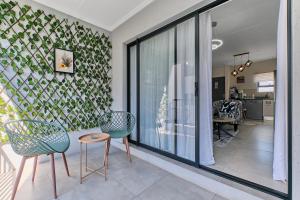 a living room with two chairs and a table at Chanty Serenity- workstation, gym, backup power &Pool in Sandton
