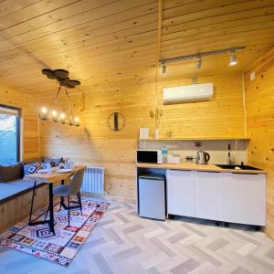 a kitchen with wooden walls and a table and chairs at Kainar Glamp Домик в горах с террасой и прекрасным видом на горы in Besqaynar