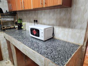 a microwave sitting on a counter in a kitchen at Pure excellence homes in Ruiru
