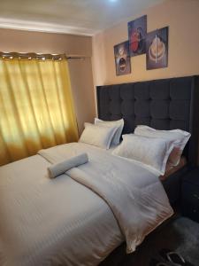 a bedroom with a large bed with white sheets and pillows at Pure excellence homes in Ruiru