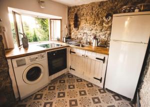 a kitchen with a washer and a sink and a refrigerator at Kamonkő Panoráma Kuckó in Szigliget +8 photos