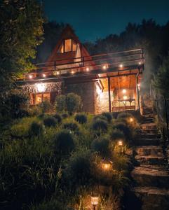 a house lit up at night with lights at Kamonkő Panoráma Kuckó in Szigliget