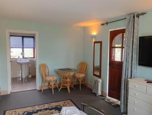 a living room with a table and chairs and a television at The Catkins, Grove flock farm in Diss