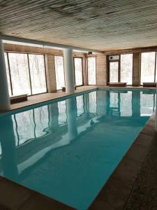 a large swimming pool with blue water in a building at La marmotte namuroise in Saint-Jean-d'Aulps