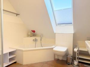 a bathroom with a tub and a toilet and a window at 1006 - Haus Seesternweg in Dahme +18 photos