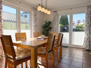 a dining room with a table and chairs and windows at 1006 - Haus Seesternweg in Dahme