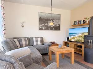 a living room with a couch and a tv at 1006 - Haus Seesternweg in Dahme