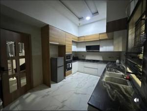 a large kitchen with a sink and a refrigerator at Jolie Homes in Lekki
