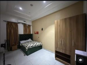 a bedroom with a bed and wooden cabinets at Jolie Homes in Lekki