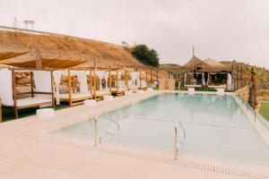 a swimming pool at a resort with white chairs at Escua in Archidona
