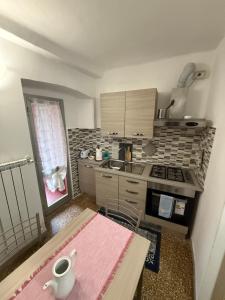 a small kitchen with a table and a counter top at Tramonto in Mele +22 photos