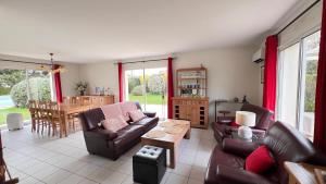 a living room with couches and a table at Les Ptis Bregeons in Talmont +7 photos